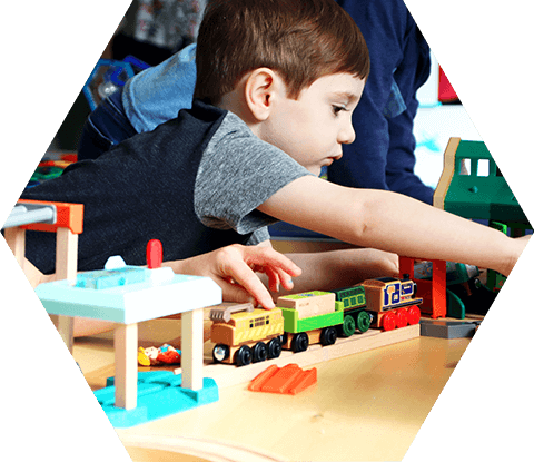 Small boy with wooden train set