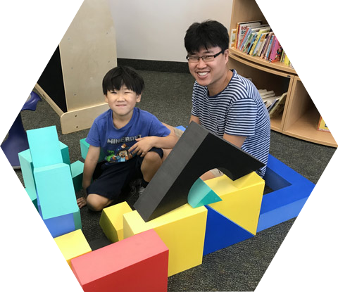 Father and son building with large foam blocks