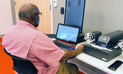 Man viewing Florida Sentinel Bulletin on document scanner